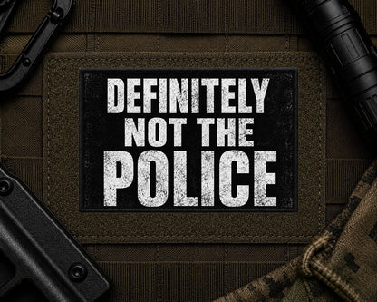 Definitely Not The Police Patch design with a black border on tactical gear.